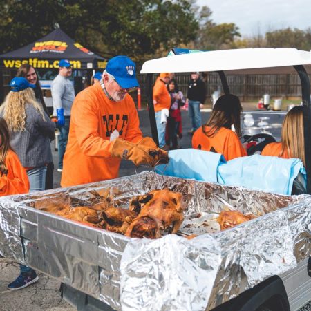 Turkey Fry volunteers drive a golf cart filled with cooked turkeys to the cooling station.
