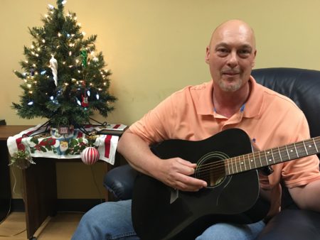 Russell Weaver playing guitar and celebrating Christmas at Overcomers Center